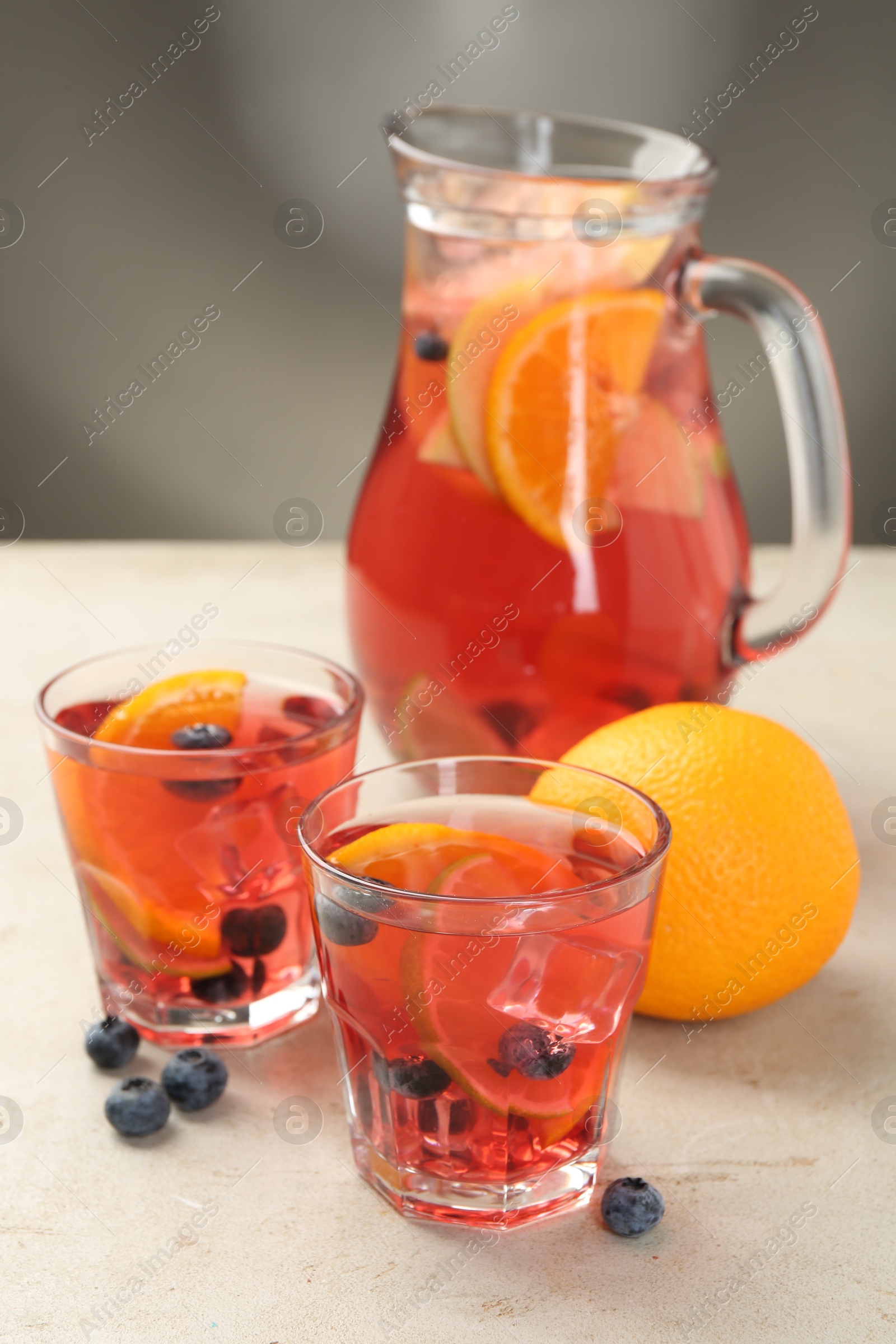 Tasty fruity punch on light gray textured table, closeup Photo of Tasty fruity punch on light gray textured table, closeup