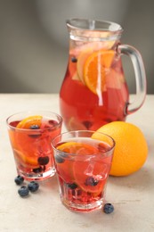 Photo of Tasty fruity punch on light gray textured table, closeup