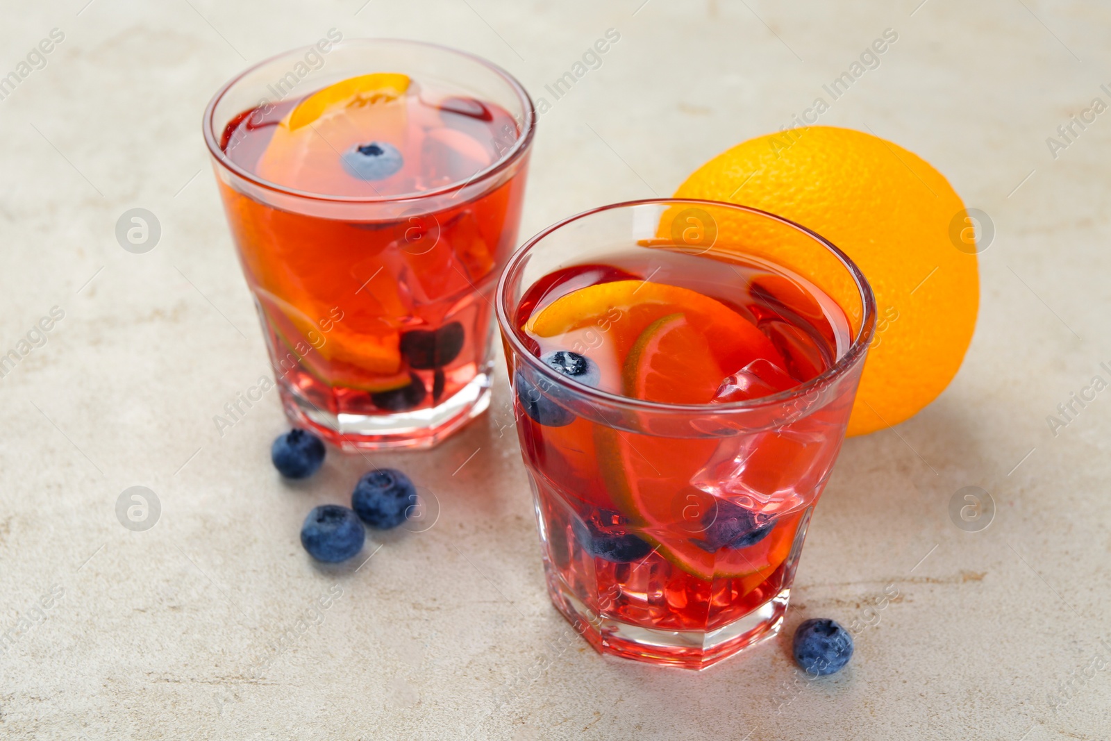 Tasty fruity punch in glasses on light gray textured table, closeup Photo of Tasty fruity punch in glasses on light gray textured table, closeup