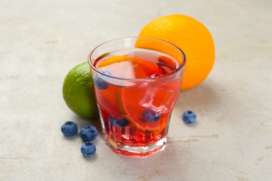 Photo of Tasty punch, fruits and berries on light gray textured table, closeup
