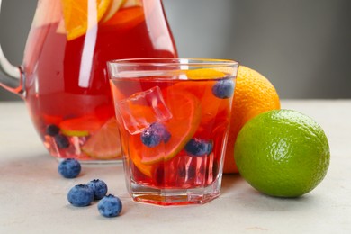 Photo of Tasty punch, fruits and berries on light gray table, closeup