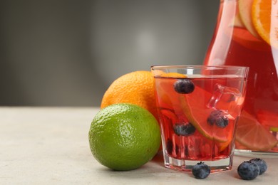 Photo of Tasty punch, fruits and berries on light gray table, closeup