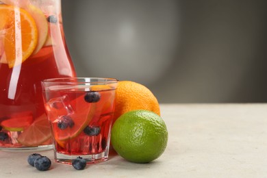 Photo of Tasty punch, fruits and berries on light gray table, closeup