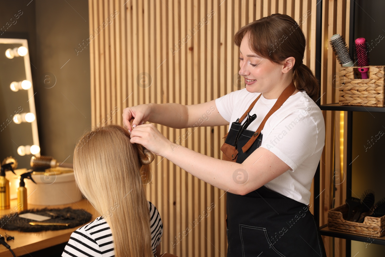 Photo of Professional hairstylist working with client in salon