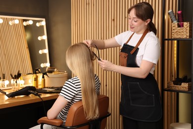 Photo of Professional hairstylist working with client in salon