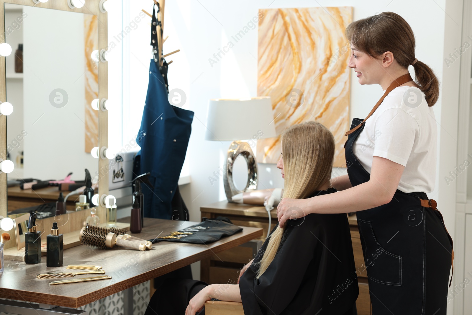 Professional hairstylist working with client in salon Photo of Professional hairstylist working with client in salon