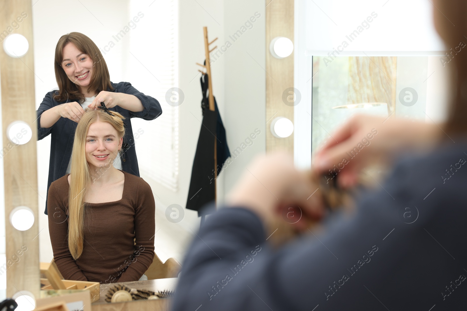 Professional hairstylist working with client in salon Photo of Professional hairstylist working with client in salon