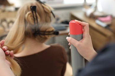 Photo of Professional hairstylist working with client in salon, closeup