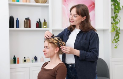 Photo of Professional hairstylist working with client in salon