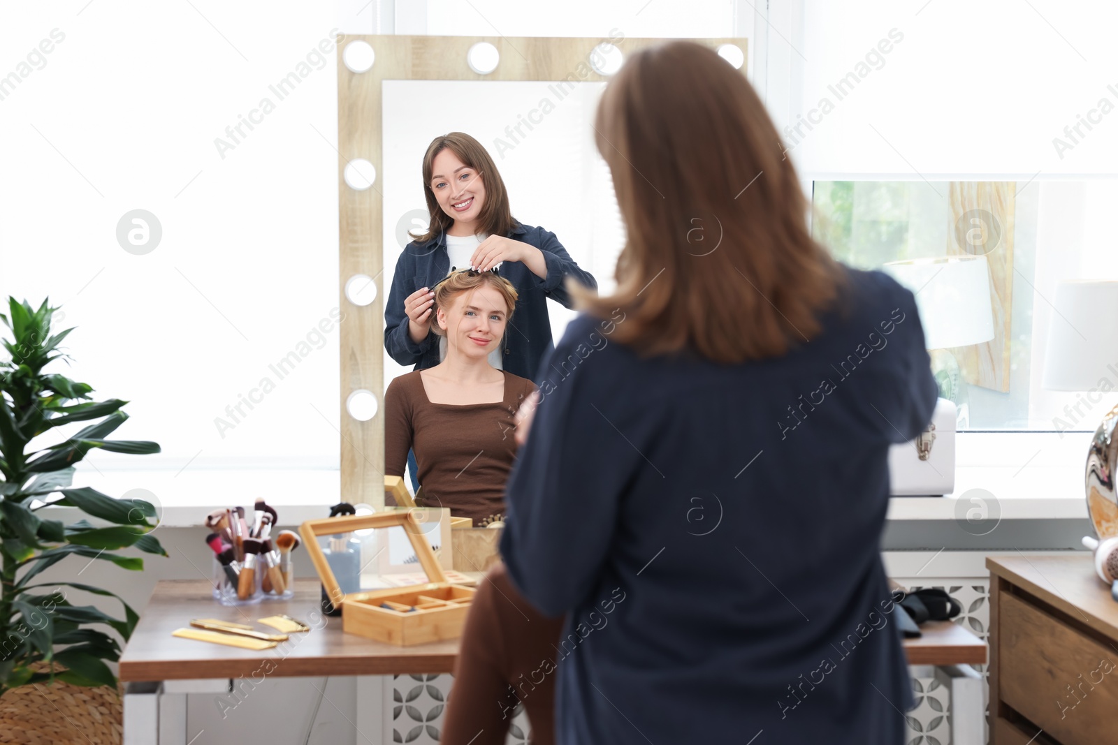 Professional hairstylist working with client in salon Photo of Professional hairstylist working with client in salon