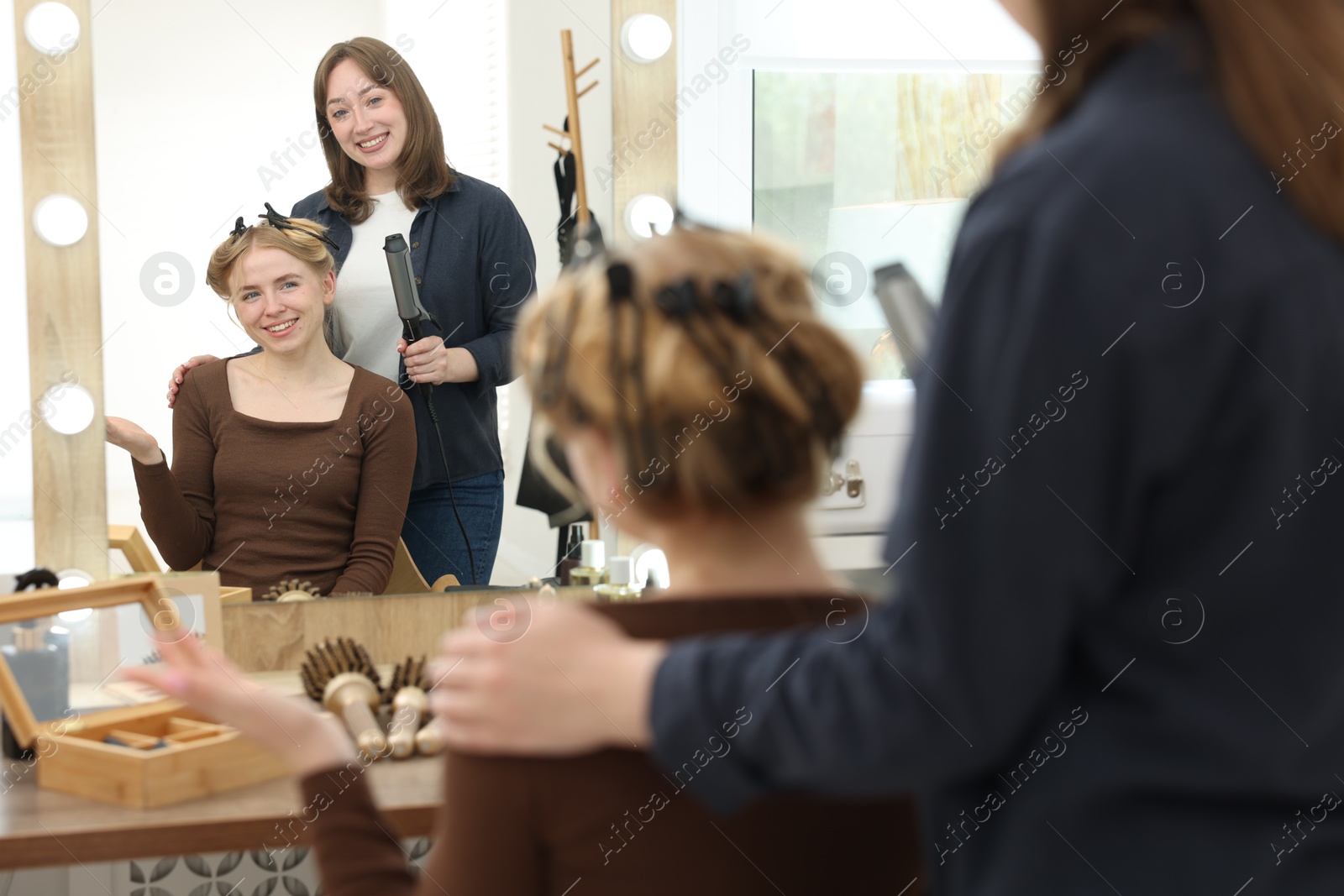 Professional hairstylist working with client in salon Photo of Professional hairstylist working with client in salon