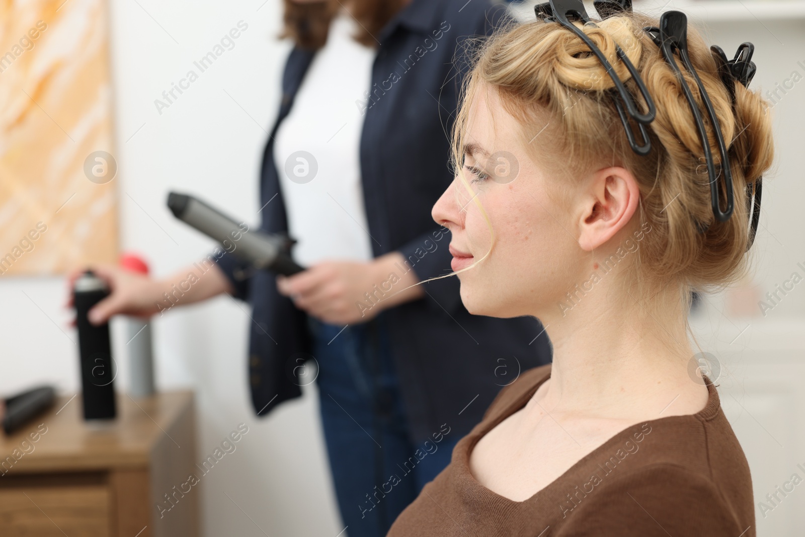 Professional hairstylist working with client in salon, selective focus Photo of Professional hairstylist working with client in salon, selective focus