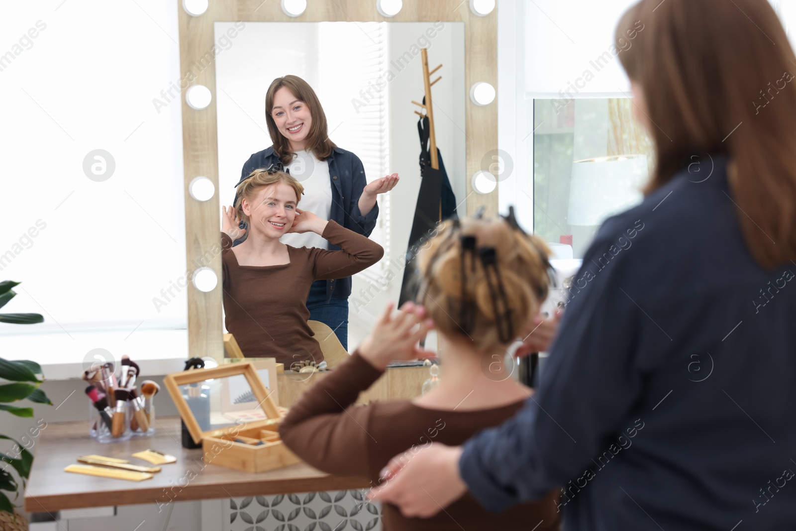 Professional hairstylist working with client in salon Photo of Professional hairstylist working with client in salon