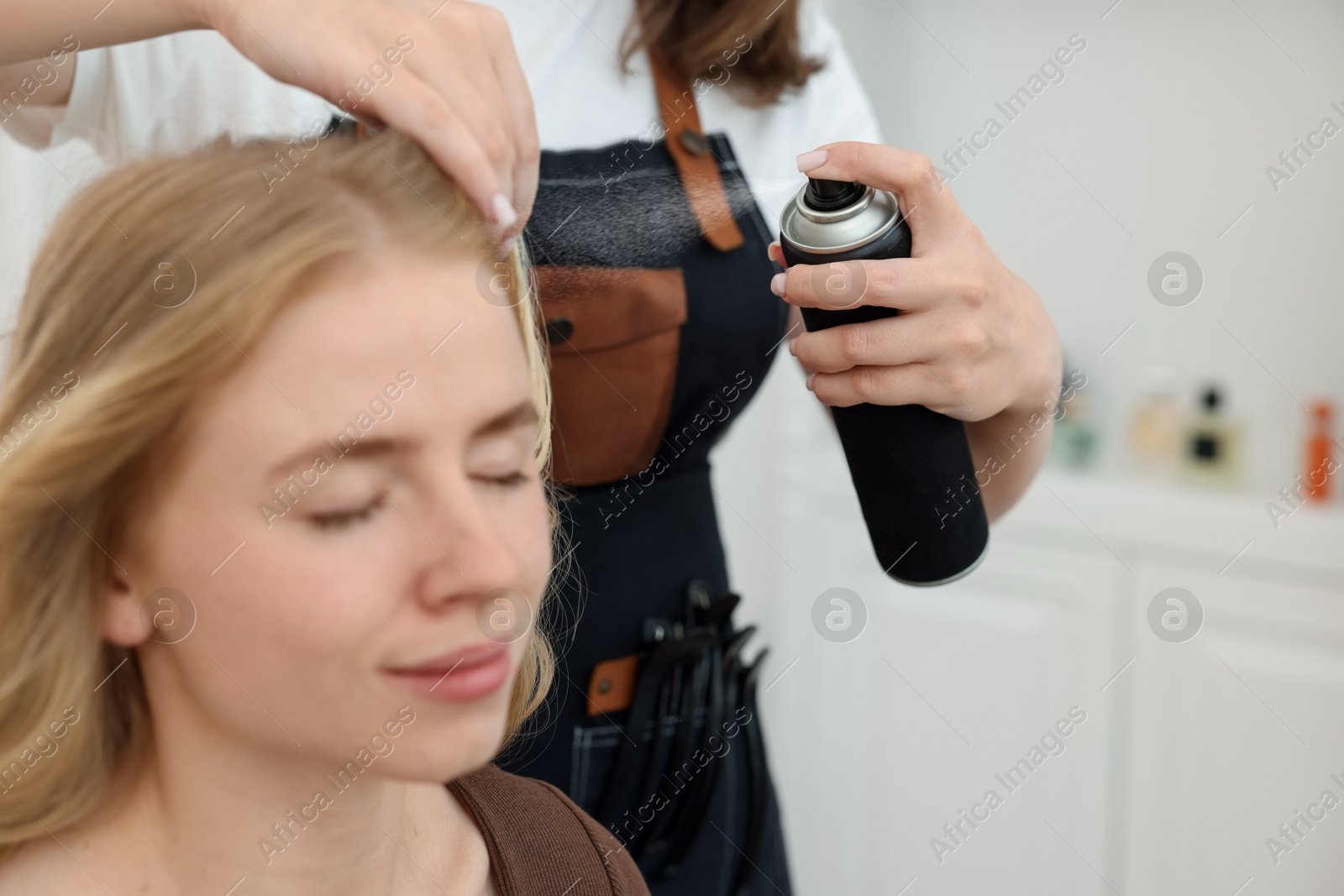 Professional hairstylist working with client in salon, closeup Photo of Professional hairstylist working with client in salon, closeup