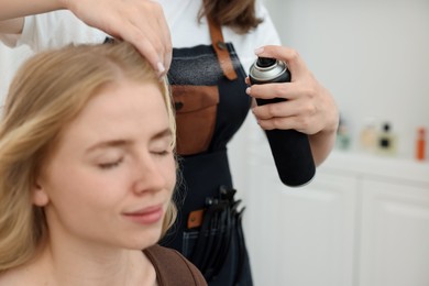 Photo of Professional hairstylist working with client in salon, closeup