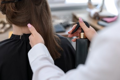 Photo of Professional hairstylist working with client in salon, closeup