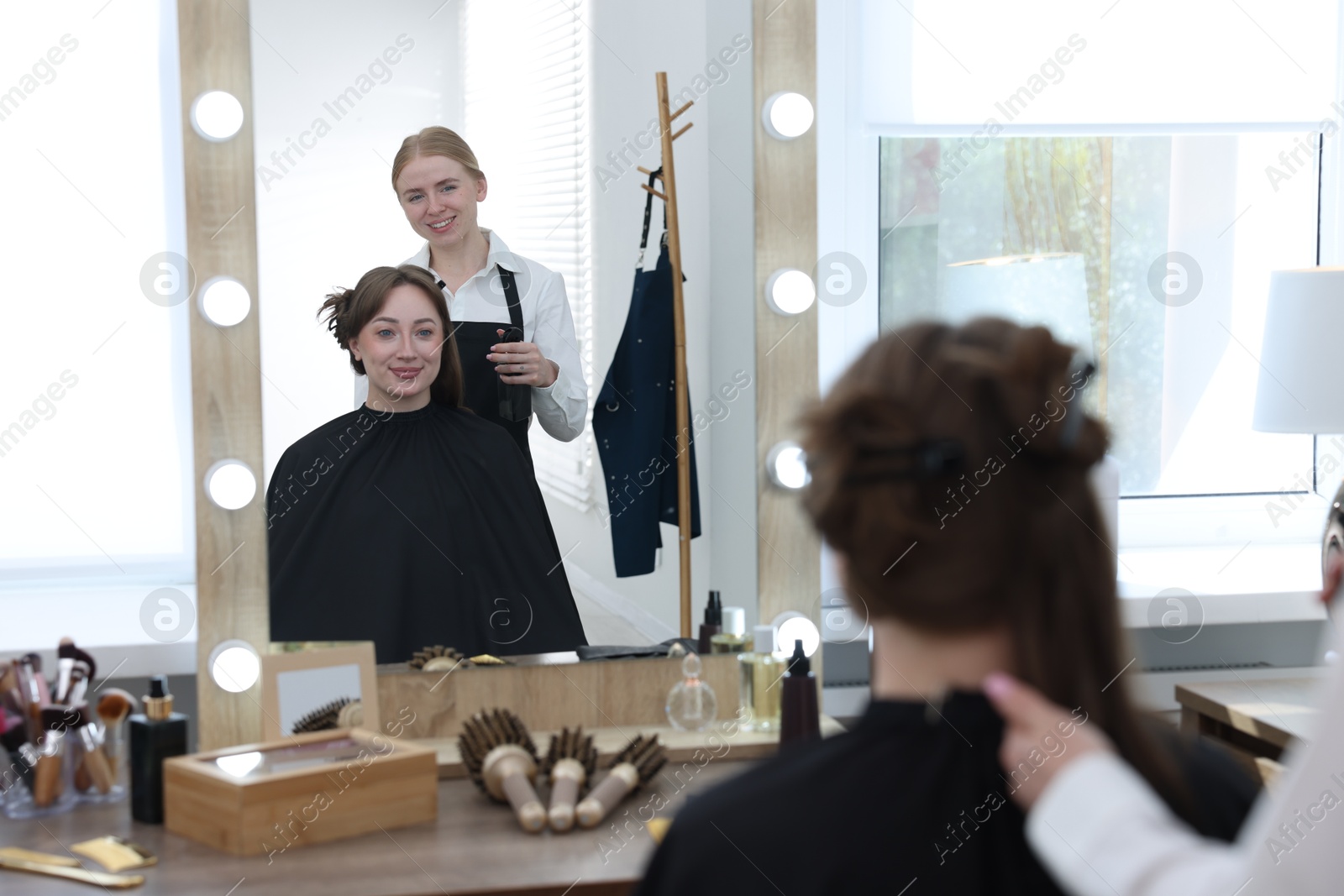 Professional hairstylist working with client in salon Photo of Professional hairstylist working with client in salon