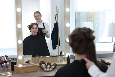 Photo of Professional hairstylist working with client in salon