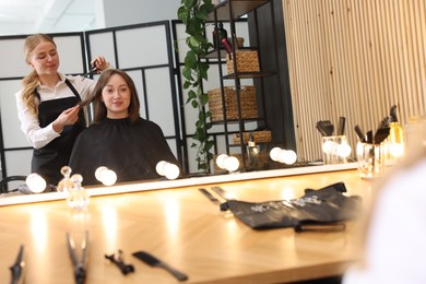 Photo of Hairstylist cutting client's hair with scissors in salon