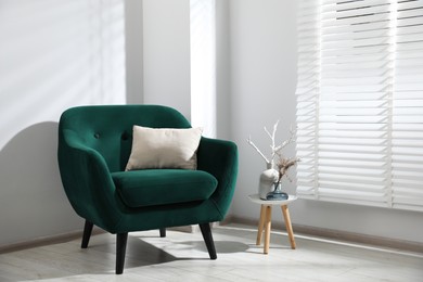 Photo of Comfortable armchair and decor near window in light room