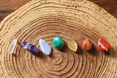 Photo of Aura. Different natural mineral stones on stump, flat lay