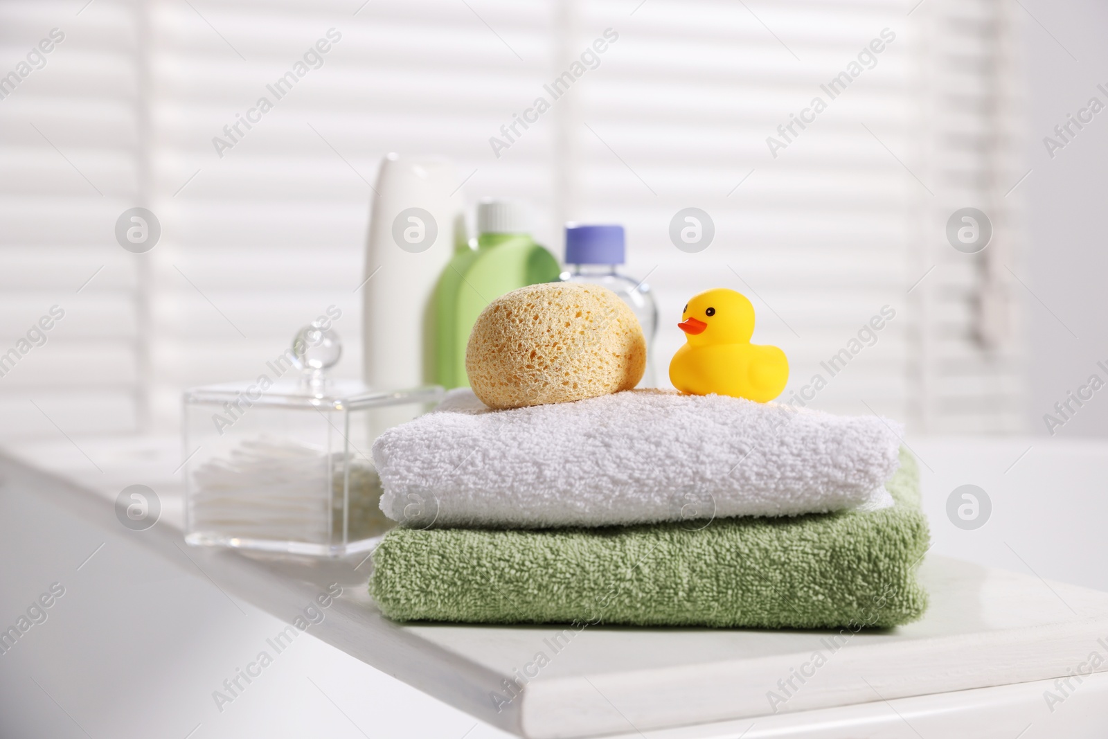 Photo of Baby accessories and bathing products on tray in bathtub indoors, closeup
