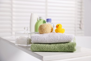 Photo of Baby accessories and bathing products on tray in bathtub indoors, closeup