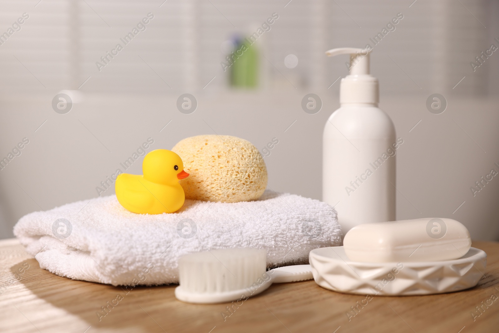 Photo of Baby accessories and bathing products on wooden table in bathroom, closeup