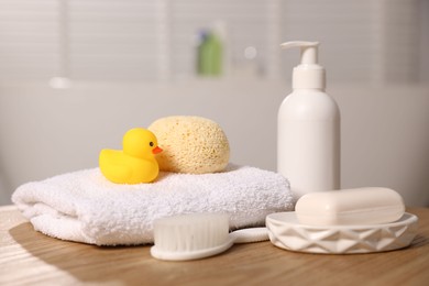 Photo of Baby accessories and bathing products on wooden table in bathroom, closeup