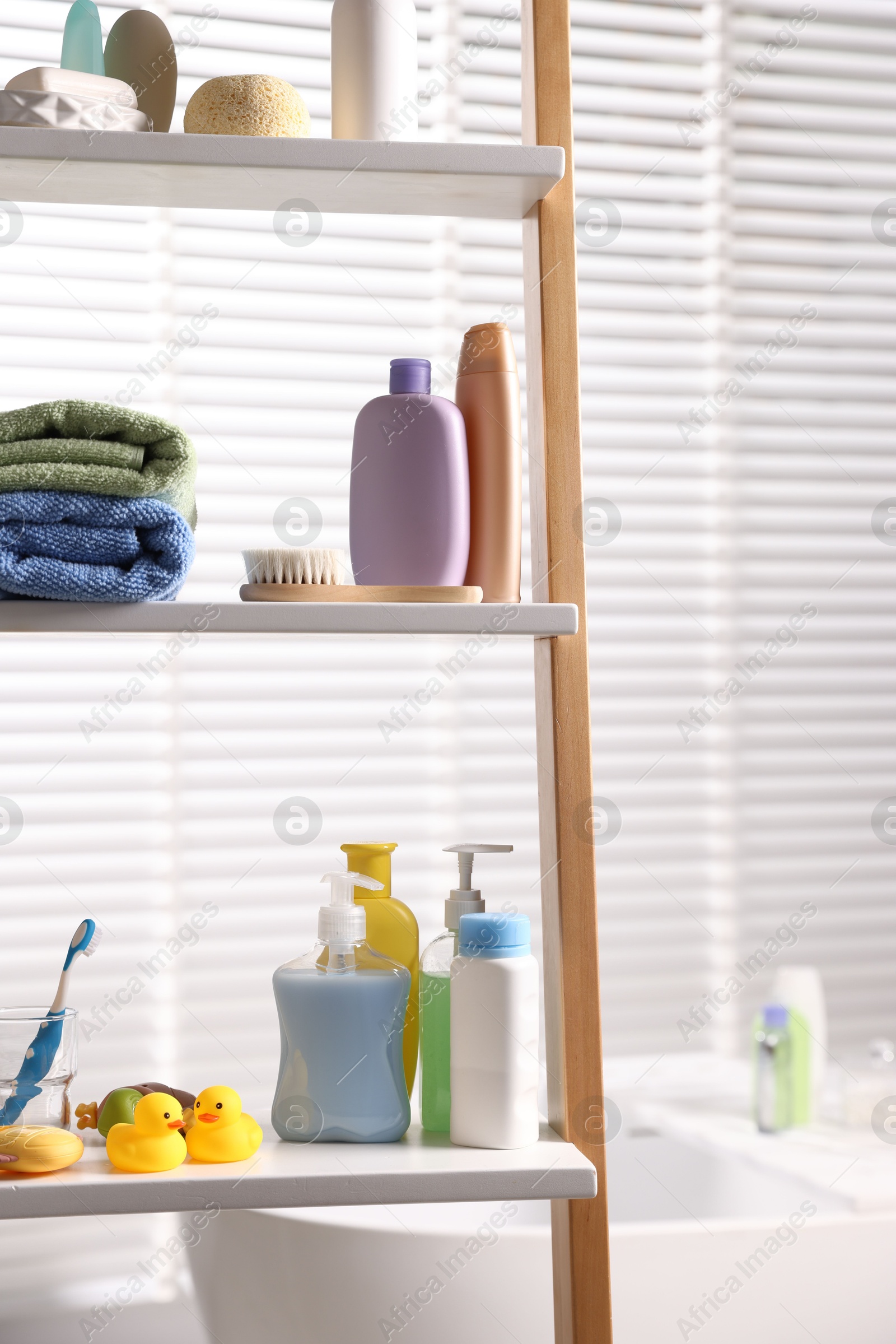 Photo of Baby bath accessories and care products on rack in bathroom