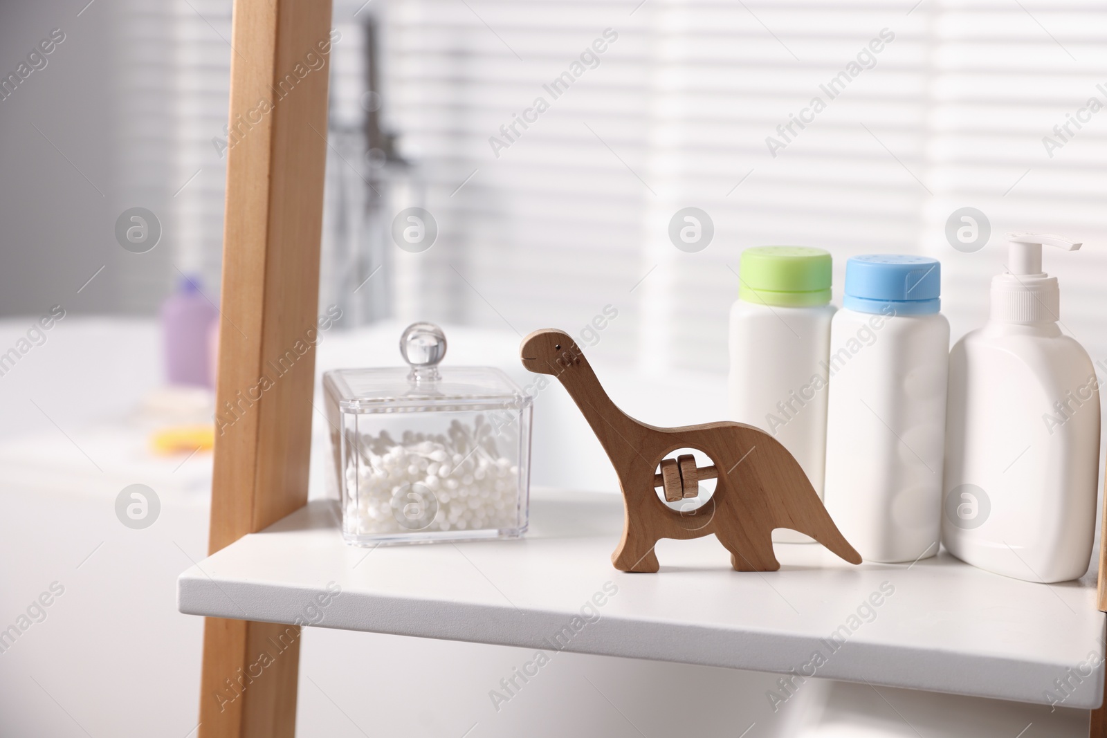 Photo of Baby bath accessories and care products on rack in bathroom, closeup