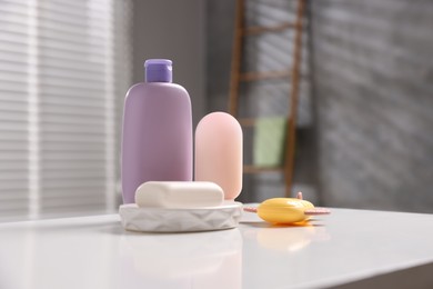Photo of Baby accessories and bathing products on white table in bathroom