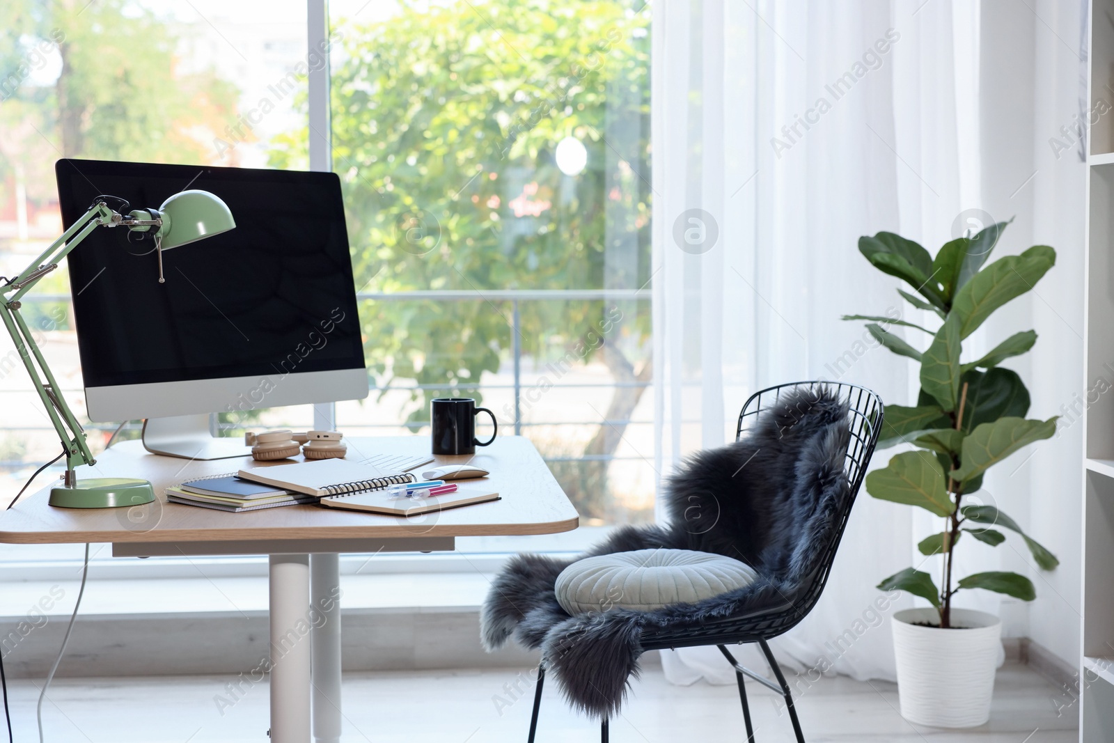 Photo of Home workspace. Modern computer, houseplant and stationery on wooden desk indoors