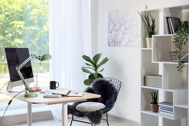 Photo of Home workspace. Modern computer, houseplant and stationery on wooden desk indoors