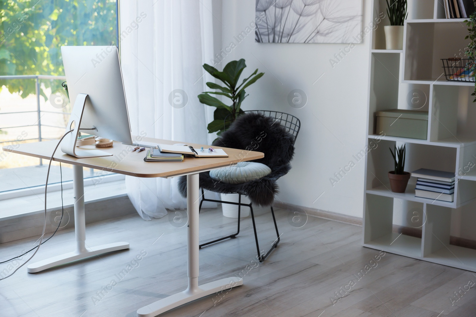 Photo of Home workspace. Modern computer, houseplant and stationery on wooden desk indoors