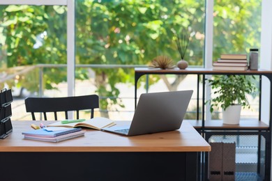 Photo of Home workspace. Modern laptop and stationery on wooden desk indoors