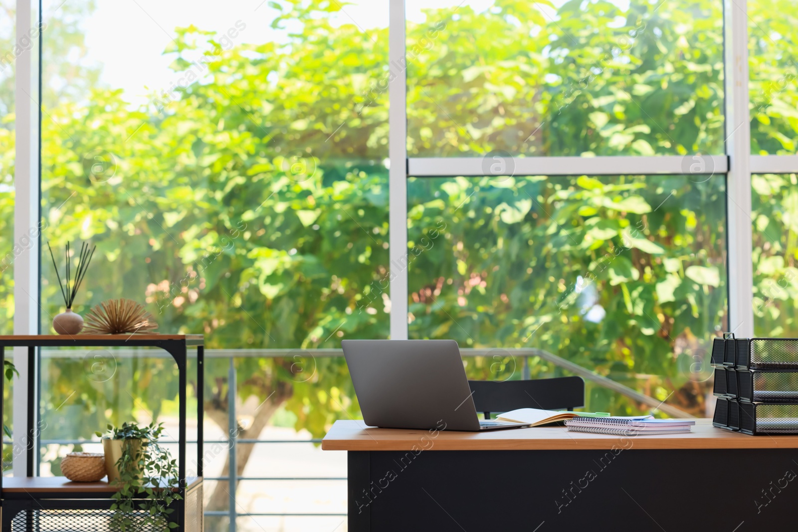 Photo of Home workspace. Modern laptop and stationery on wooden desk indoors