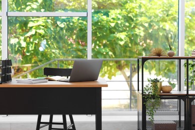 Photo of Home workspace. Modern laptop and stationery on wooden desk indoors