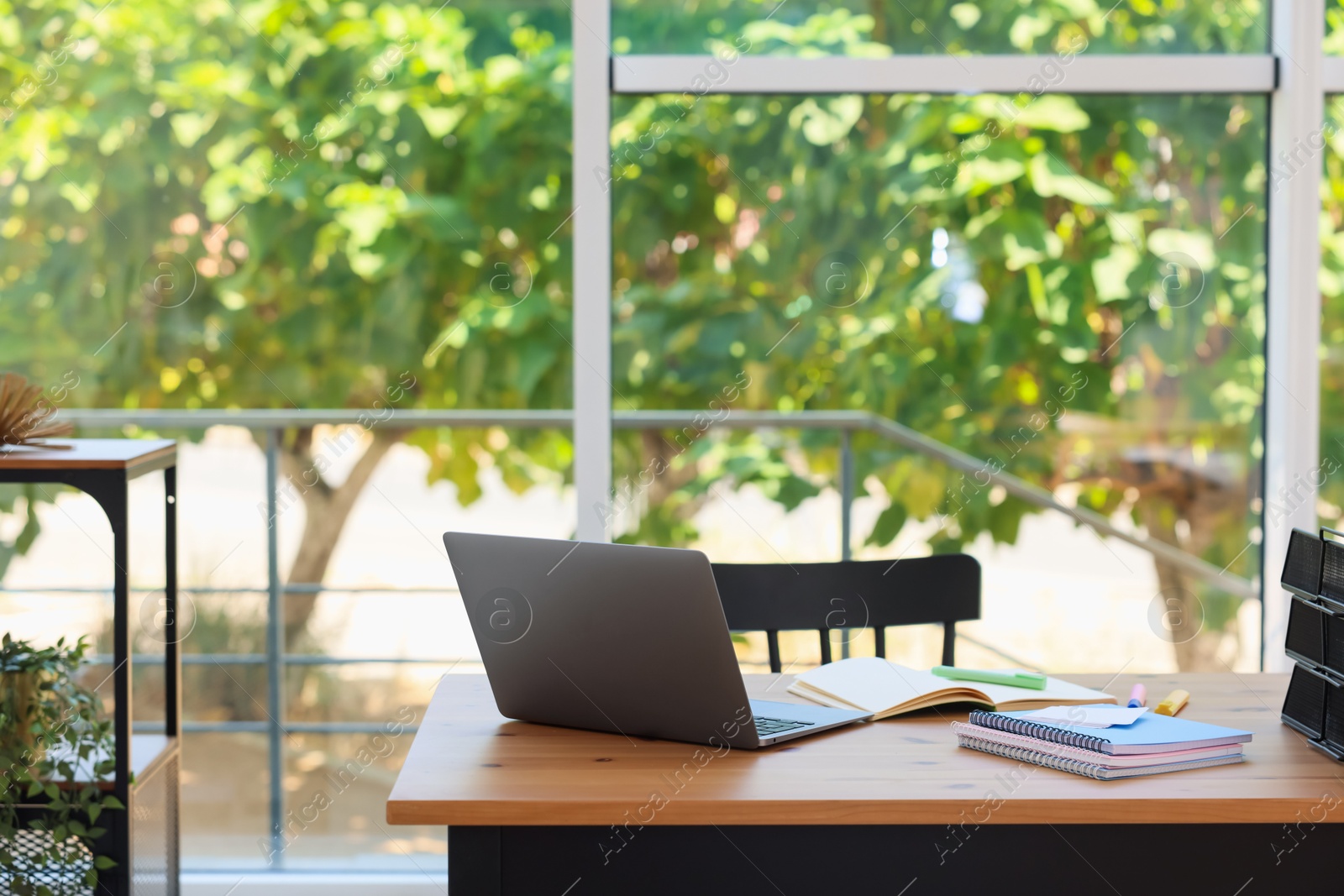 Photo of Home workspace. Modern laptop and stationery on wooden desk indoors