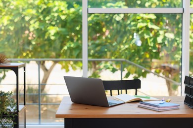 Photo of Home workspace. Modern laptop and stationery on wooden desk indoors