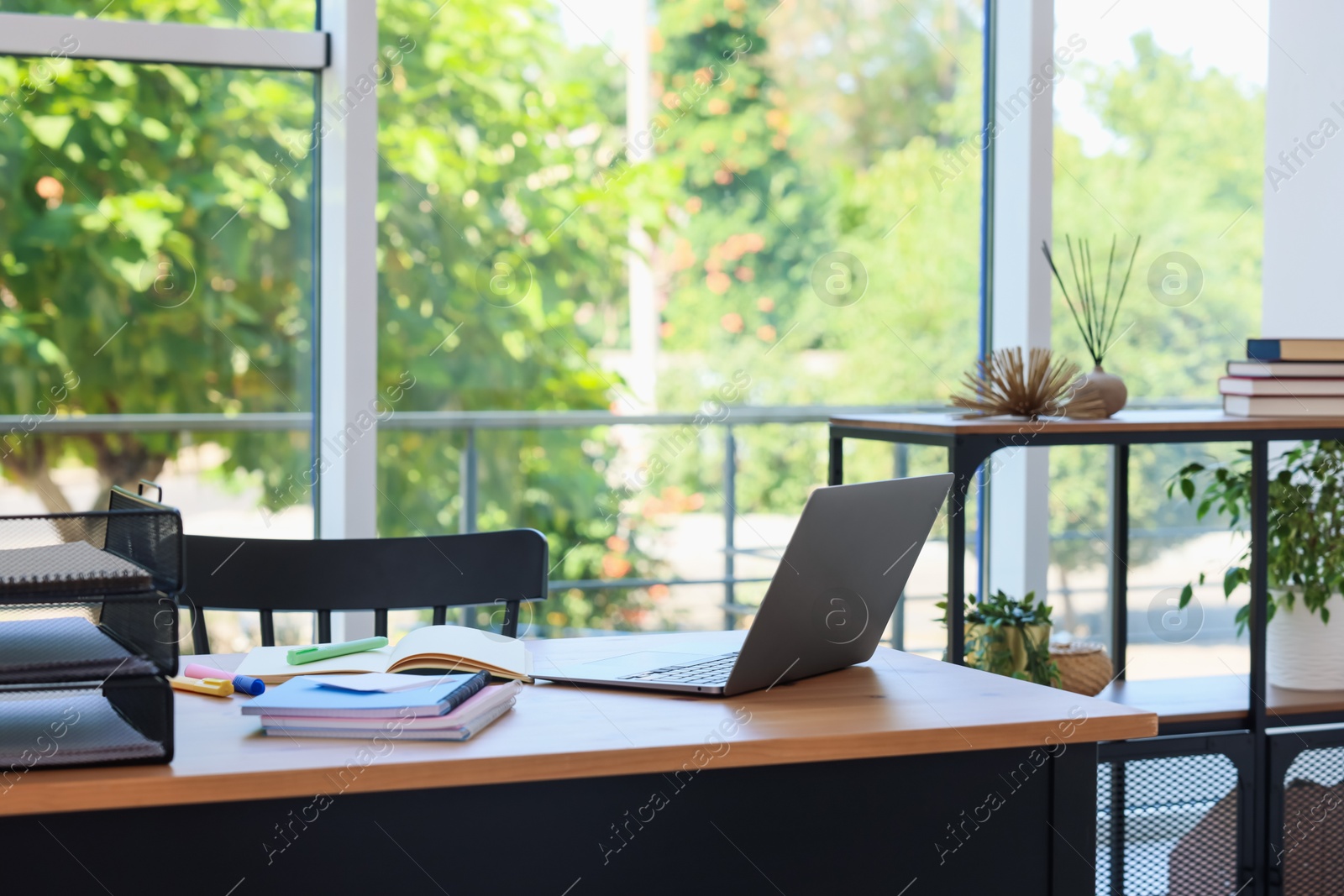 Photo of Home workspace. Modern laptop and stationery on wooden desk indoors