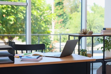 Photo of Home workspace. Modern laptop and stationery on wooden desk indoors
