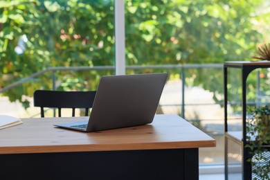 Photo of Home workspace. Modern laptop on wooden desk indoors