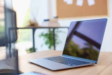 Photo of Home workspace. Modern laptop on wooden desk indoors, closeup