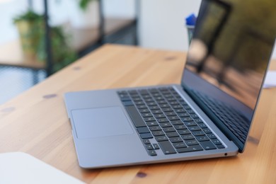 Photo of Home workspace. Modern laptop on wooden desk indoors, closeup