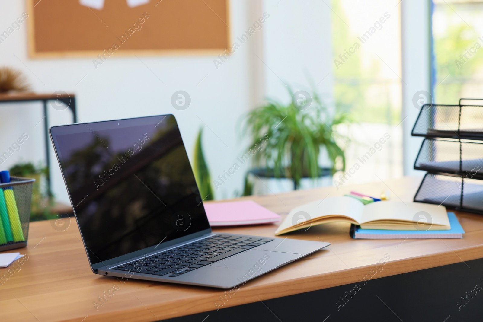 Photo of Home workspace. Modern laptop and stationery on wooden desk indoors