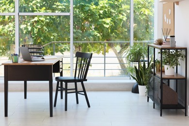 Photo of Home workspace. Modern laptop and stationery on wooden desk indoors