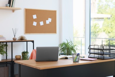 Photo of Home workspace. Modern laptop and stationery on wooden desk indoors
