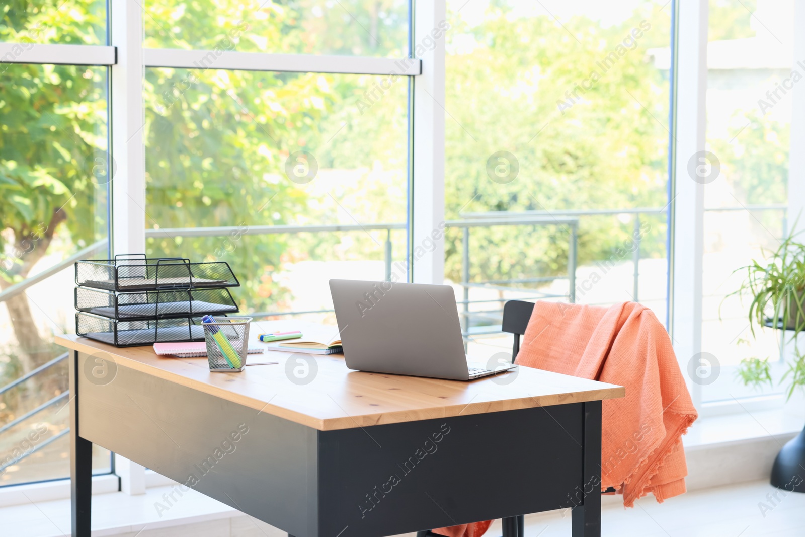 Home workspace. Modern laptop and stationery on wooden desk indoors Photo of Home workspace. Modern laptop and stationery on wooden desk indoors