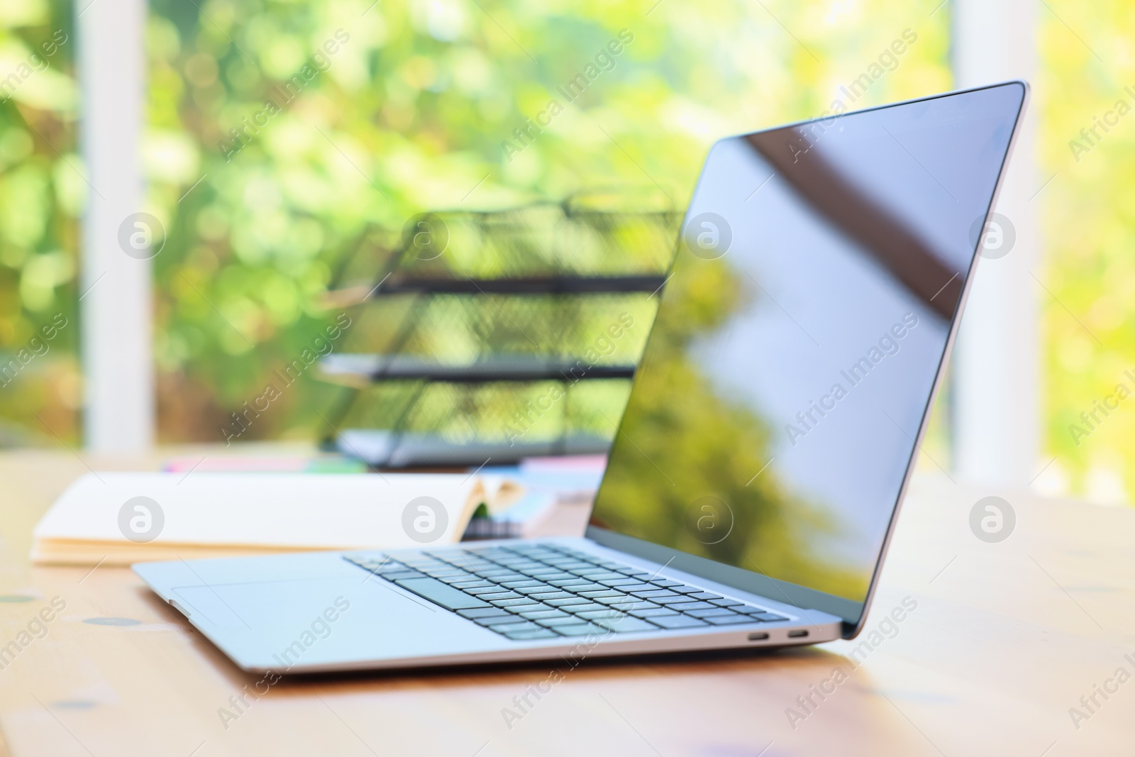 Home workspace. Modern laptop and stationery on wooden desk indoors Photo of Home workspace. Modern laptop and stationery on wooden desk indoors